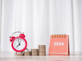 estudiar objetivos, 2024 escritorio calendario, rojo alarma en apilar de monedas el concepto de ahorro dinero y gestionar hora para educación, estudiante préstamo, beca, matrícula Tarifa en nuevo año 2024 foto