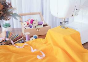 Close up of sewing machine working with yellow fabric,  stitch new clothing. photo