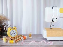 Sewing machine working with yellow fabric, sewing accessories on the table, stitch new clothing. photo