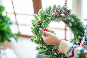 mujer haciendo muérdago guirnalda Navidad guirnalda decoración con mano hecho bricolaje invierno verdor florista manos haciendo Navidad guirnalda hermosa muérdago. foto