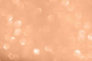 Peach Fuzz abstract glitter background with shiny bokeh photo