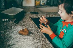 boy and his mom create special memories while preparing Christmas gingerbread for the joyful season. photo