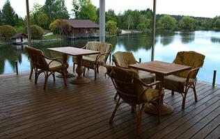 Open Wood Terrace With Wicker Armchairs And Tables photo