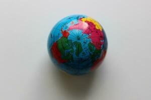 Top view of the North Pole on a miniature Earth globe on white surface photo