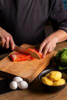 de cerca de vestido en negro cocinero cortes con cuchillo el salmón a el profesional cocina. foto