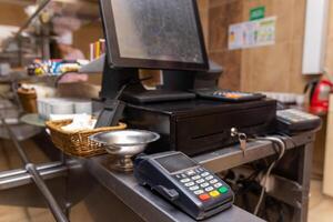 efectivo Registrarse para pago para compras en un café con un digital Terminal. foto