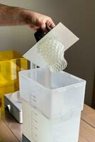 Man using a wash machine to clean a transparent 3d resin object photo