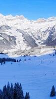 Free photo high angle shot of a beautiful mountain range covered with snow under the blue sky