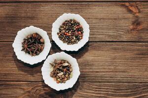 Spices anise, pepper, cumin, cumin, ginger in bowls on a wooden table photo