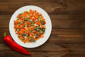 Frozen vegetables carrots, peas, beans in a plate photo