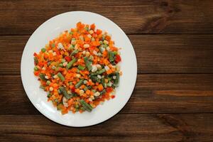 congelado vegetales zanahorias, guisantes, frijoles en un lámina. foto