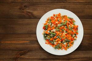 congelado vegetales zanahorias, guisantes, frijoles en un lámina. foto