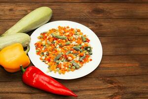 Frozen vegetables carrots, peas, beans in a plate photo