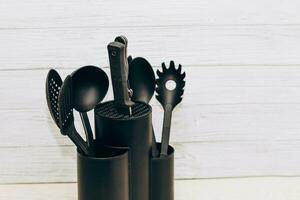 cocina herramientas el plastico para multicocina en un de madera mesa en un plato organizador. foto