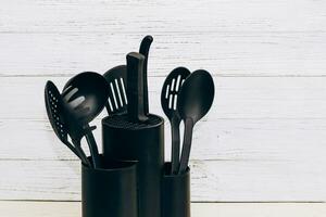 cocina herramientas el plastico para multicocina en un de madera mesa en un plato organizador. foto