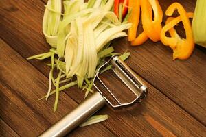 Chopped vegetables, carrots, peppers, zucchini on a vegetable peeler. photo