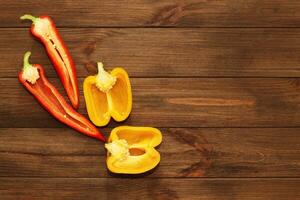 Red pepper Kapi with yellow sweet pepper on a wooden background, space for text. photo