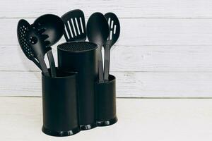 Kitchen tools plastic for multicooker on a wooden table in a dish organizer. photo