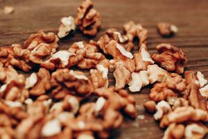 Dried walnut grains scattered on a wooden table. photo