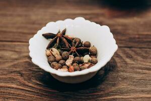 Spices anise, pepper, cumin, cumin, ginger in bowls on a wooden table. photo