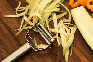 Chopped vegetables, carrots, peppers, zucchini on a vegetable peeler photo