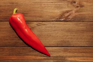 Red capi pepper on a wooden background, space for text. photo