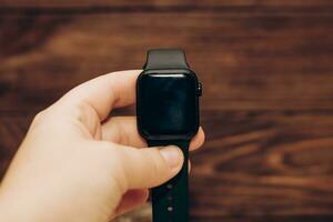 Black technological smart watch in hand. photo