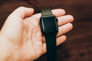 Black technological smart watch in hand. photo