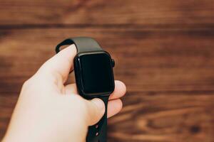 Black technological smart watch in hand. photo