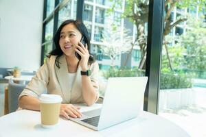 Smart asian female startup talking on the phone. Concept of selling products through telephone channels. photo