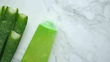 Fresh aloe vera sliced and liquid gel in plastic container on white background video