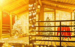 Snowcovered Christmas tree with bright white lights situated outdoors near a building, a welcoming festive moment. photo