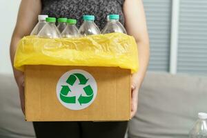 hogar reciclar eco verde cero concepto mujer lanzamiento vacío el plastico botella en reciclaje compartimiento con amarillo basura pantalones a hogar. foto