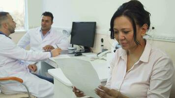 A satisfied patient studies her medical certificate video