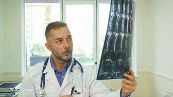 ein nachdenklich Arzt vorsichtig untersucht ein Röntgen Schuss video