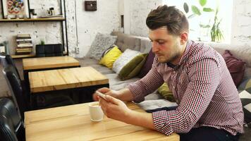 de klant is gebruik makend van zijn telefoon terwijl drinken koffie video