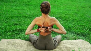 Girl is siiting in the yoga mat and doing one of the yoga poses video