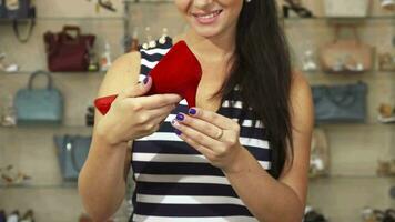 Woman examining shoe in store close up video