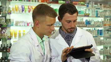 Two druggists using a tablet at work video