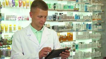 pharmacien en utilisant tablette et souriant à caméra proche en haut video