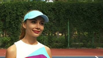 Girl with a racket smiling and looking at camera video