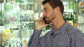 Man talking on phone about pills in drugstore video