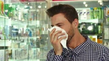 Man coughing and sneezing in drugstore video