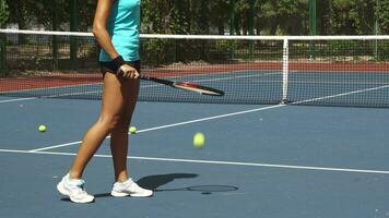 Legs of woman beating tennis racket on ball near net on court video