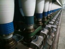 Spinning cotton into yarn in a factory. Process cotton into thread. photo