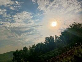 The view of the plantations is green and beautiful, there are blue clouds. See the view of the hills with blue clouds. photo