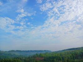 The view of the plantations is green and beautiful, there are blue clouds. See the view of the hills with blue clouds. photo