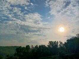 The view of the plantations is green and beautiful, there are blue clouds. See the view of the hills with blue clouds. photo