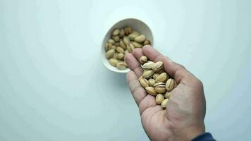 slow motion of dropping pistachios nuts in a bowl, top view video