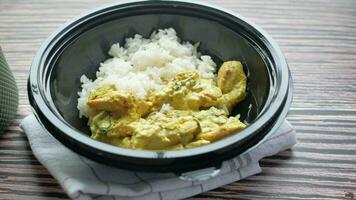 chicken biryani meal in a take away box on table. video